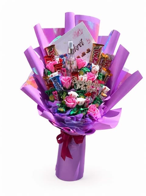 Purple gift bouquet with pink flowers, chocolates, perfume bottles, and decorative elements wrapped in purple cellophane with a burgundy bow