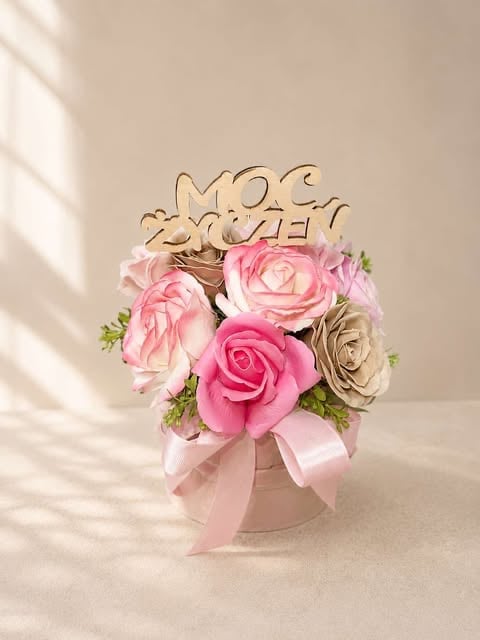 Floral arrangement with pink and cream roses in a white box topped with a wooden Just Married cake topper and pink ribbon
