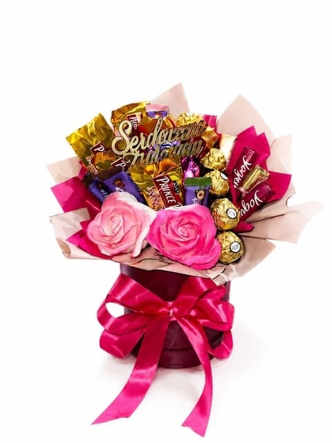 Pink and gold chocolate bouquet with two roses, assorted chocolates, and pink ribbon bow on white background